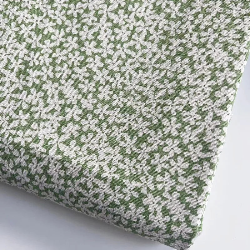 Fabric with white floral pattern on a green background