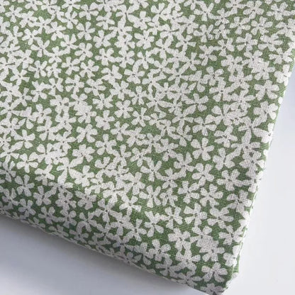 Fabric with white floral pattern on a green background