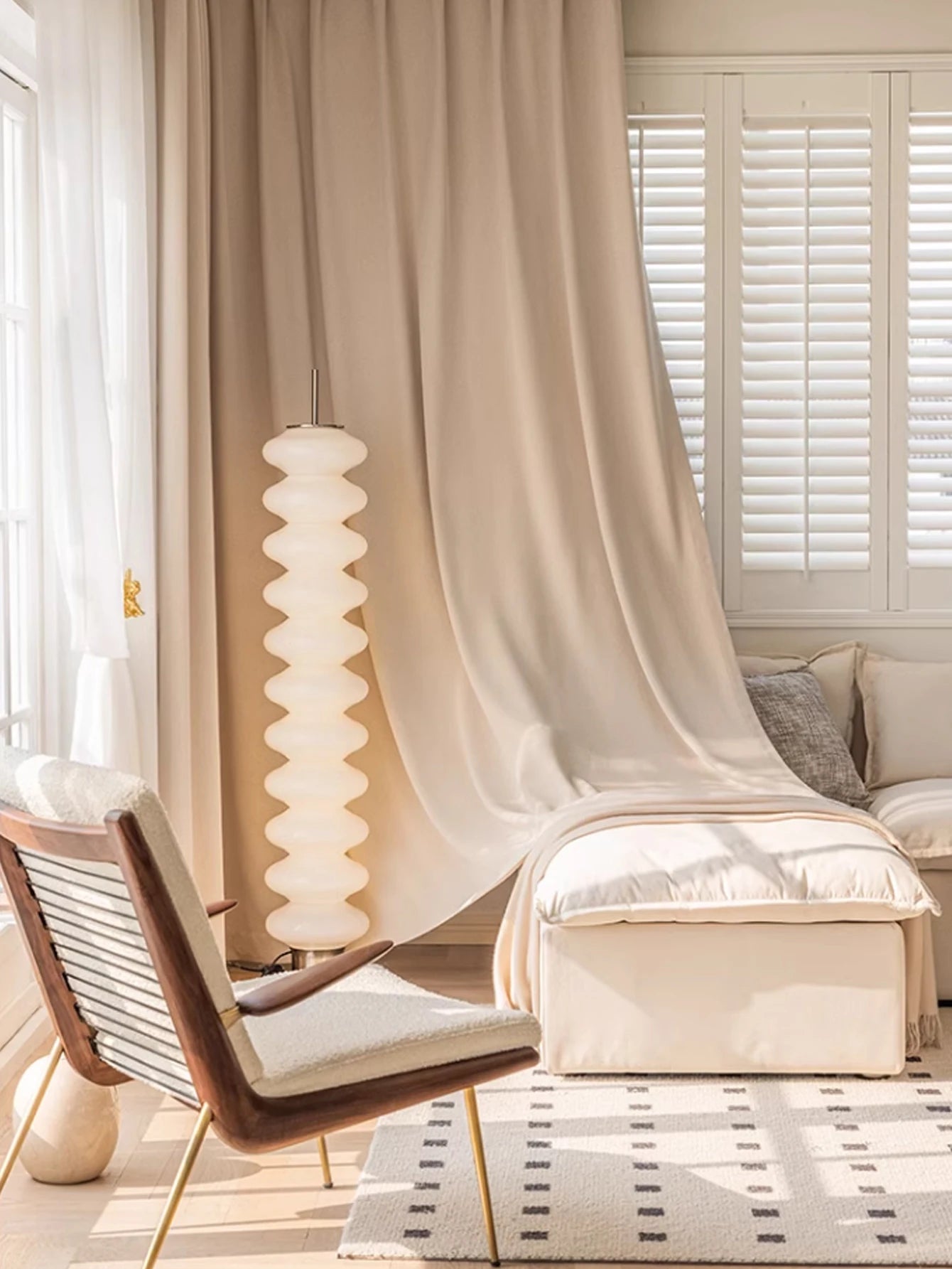 Modern living room with a chaise lounge, pendant light, and draped curtains.