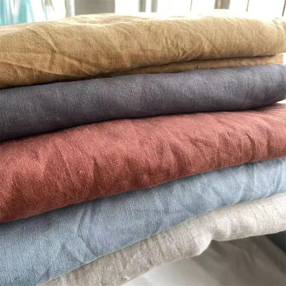 Stack of fabric swatches in various colors on a white surface