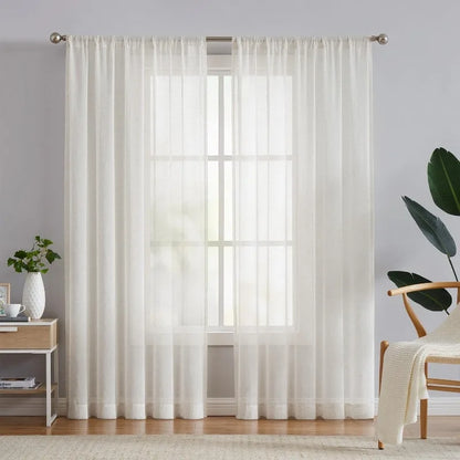 Sheer white curtains in a room with a small table and chair.
