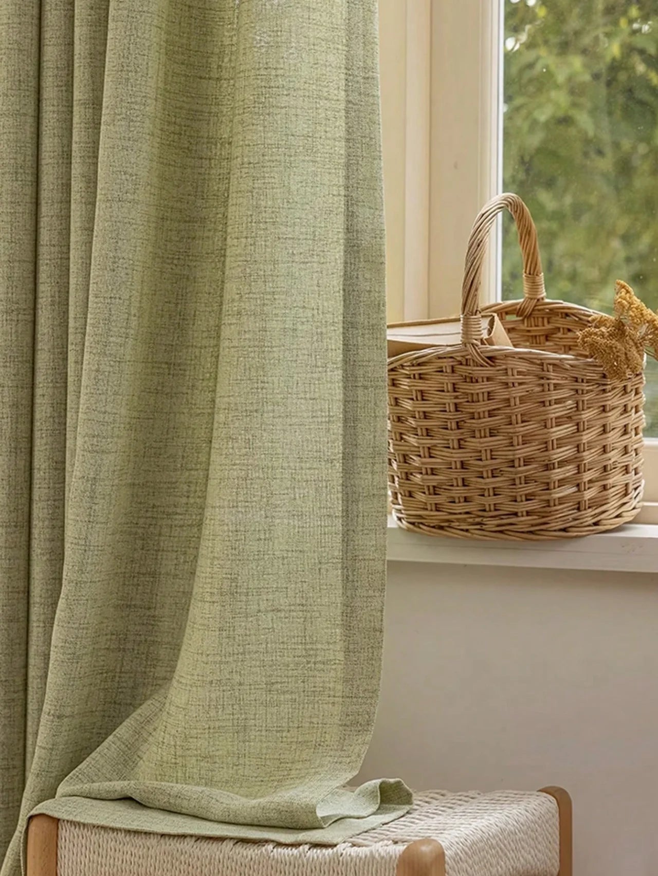 Green curtain with a woven basket on a windowsill