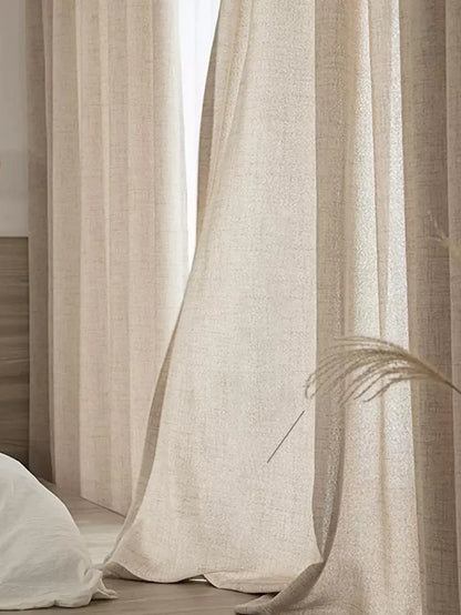 Beige curtains with a dried plant in a softly lit room
