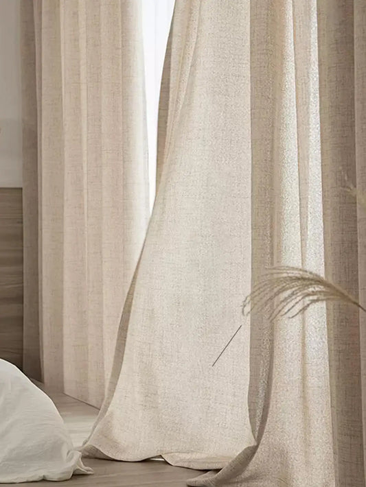 Beige curtains with a dried plant in a softly lit room