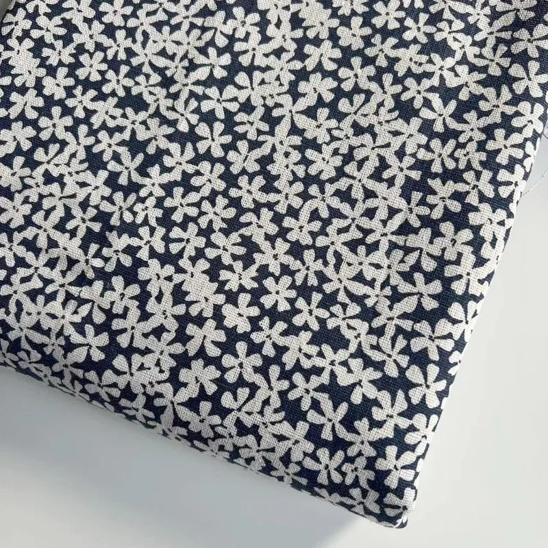 Navy blue fabric with small white floral pattern