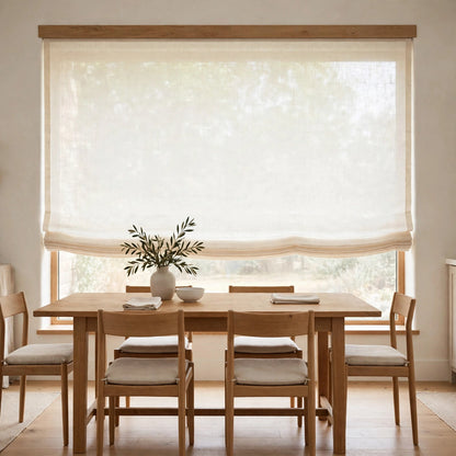 Ivory sheer linen flat Roman shade half raised in a bright dining room