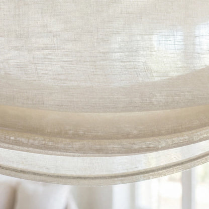 Close-up of the soft bottom folds and gentle curve of an ivory sheer linen relaxed Roman shade