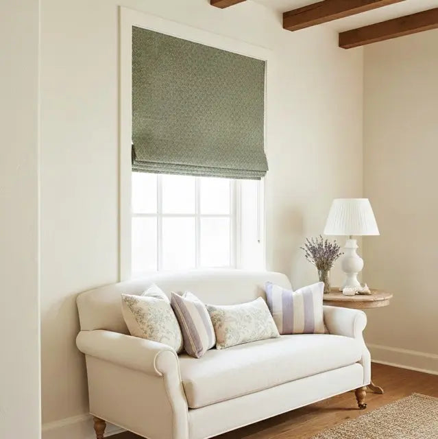 Living room with a white sofa, lamp, and window with a green flat roman shade.