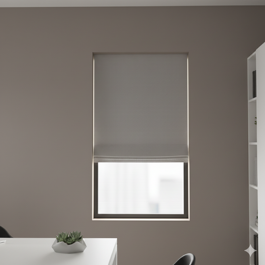Window with a light grey linen flat roman shade in a room with a table and plant.