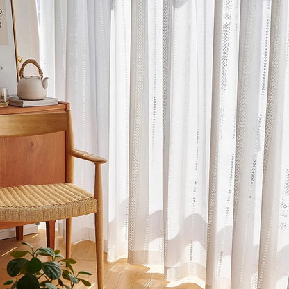 White lace sheer curtain with vertical lace stripes hanging in a bright room with a wooden chair, CD1049