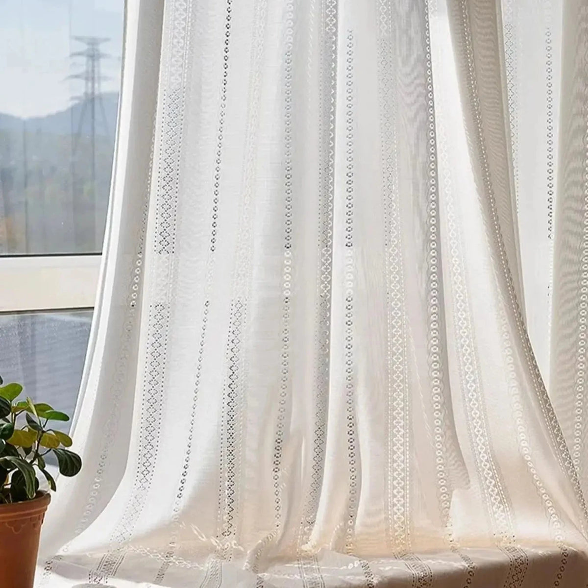White lace sheer curtain pooled softly on a window seat, CD1049
