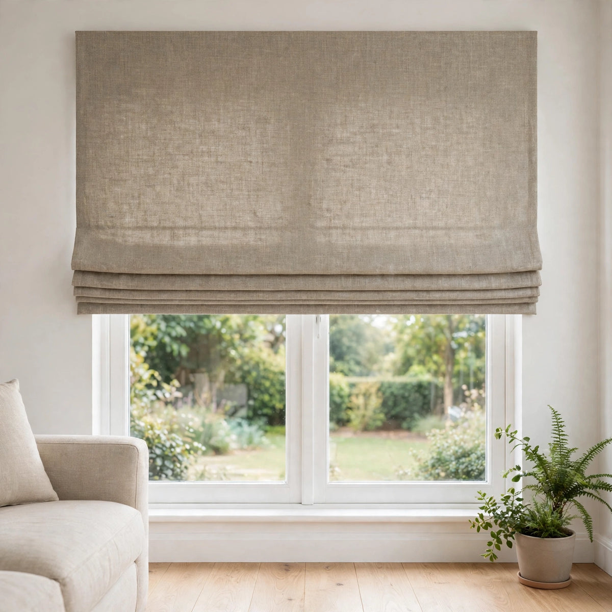 Natural Belgian linen flat Roman shade half raised with neat folds in a bright living room