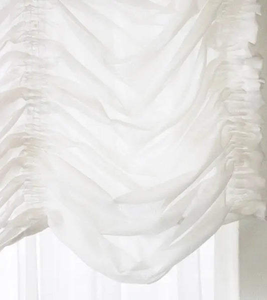 White ruffled austrian shade with a blurred background