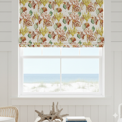 Window with sea life patterned roman blind and view of ocean.