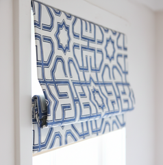 Blue geometric patterned roman blind on a window