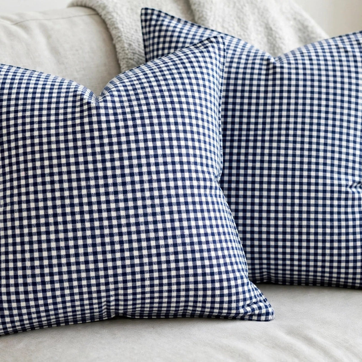 Navy gingham linen cushion covers on a gray sofa