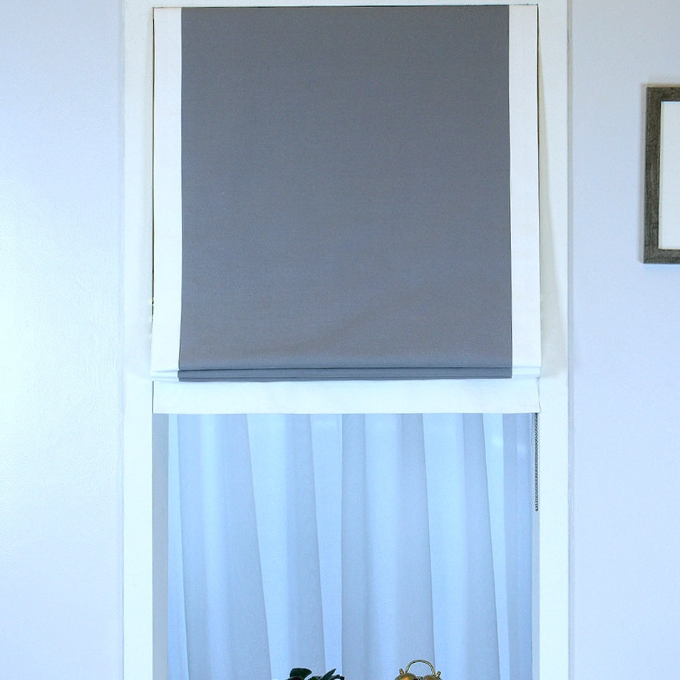 Window with a grey roman shade and white frame
