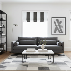 Modern living room with a striped flat roman shade, a gray sofa, coffee table, and abstract art on the wall.