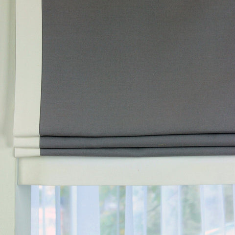 Grey 100% linen flat roman shade with white decorative trims.