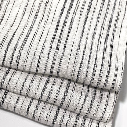 Close-up of a folded piece of linen fabric with a narrow irregular stripe pattern.
