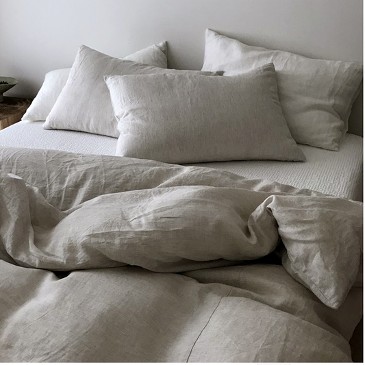A stonewashed linen duvet cover set in natural beige color displayed on a bed with matching pillowcases.