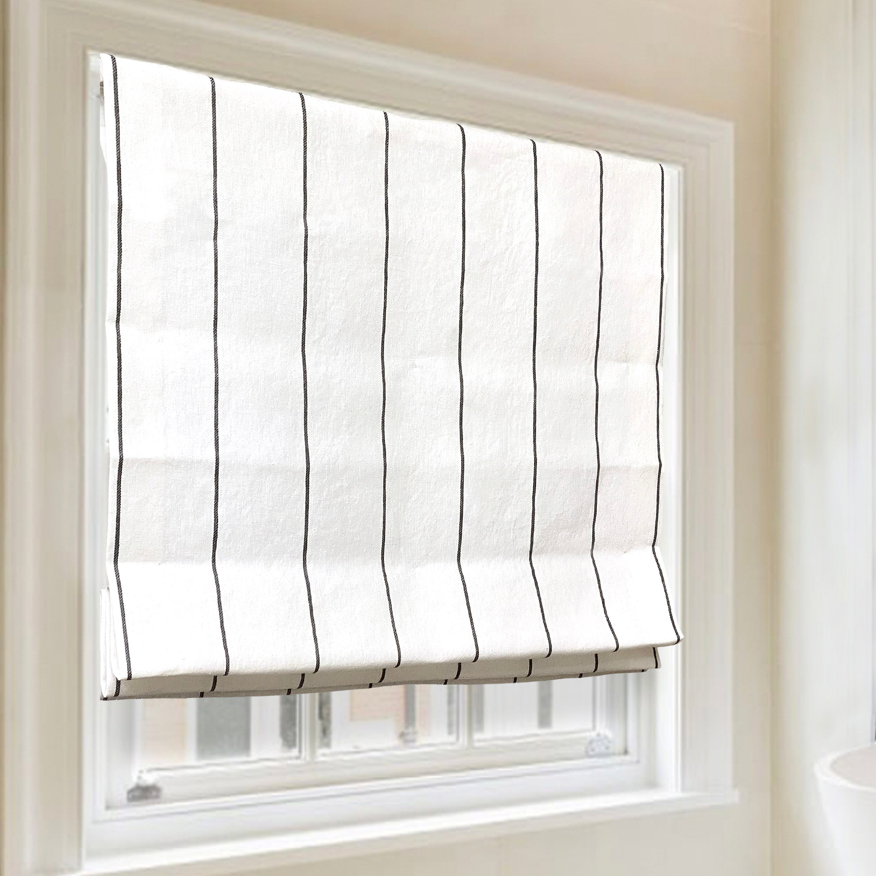 Wide Thin striped linen flat roman shade on the window.