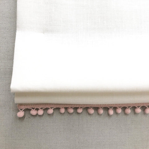  White linen flat roman shade with pink pom pom